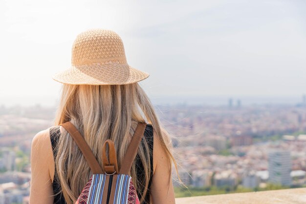 Blonde Frau mit Tasche, die die Stadt betrachtet