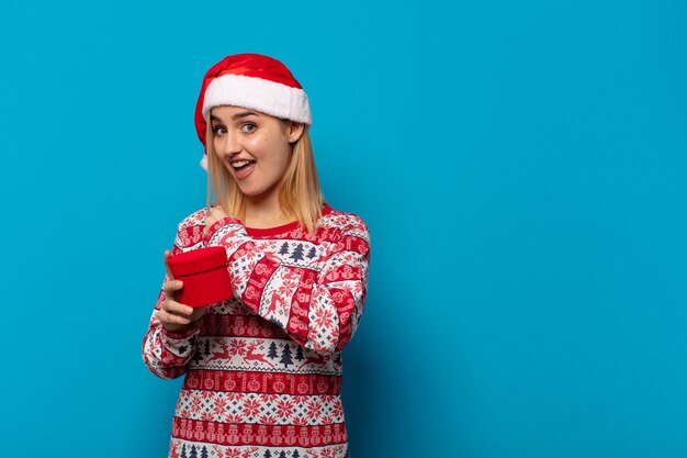 Blonde Frau mit Weihnachtsmütze fühlt sich glücklich, positiv und erfolgreich, motiviert, wenn sie sich einer Herausforderung stellt oder gute Ergebnisse feiert