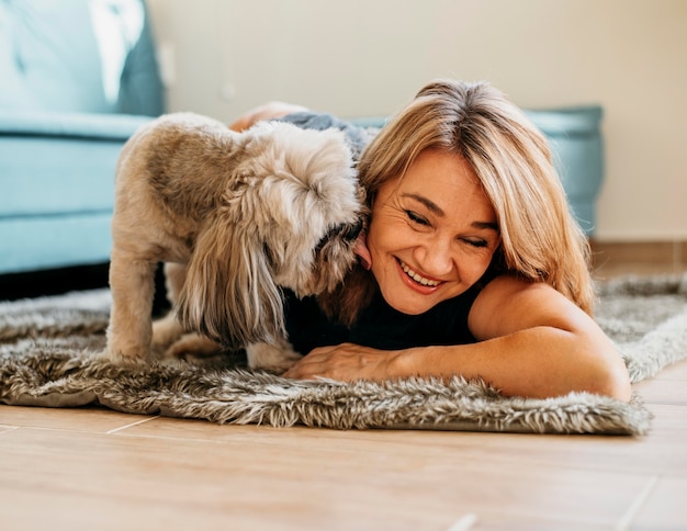 Foto blonde frau streichelt niedlichen kleinen hund