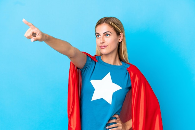 Blonde Frau über isoliertem Hintergrund im Superheldenkostüm mit stolzer Geste