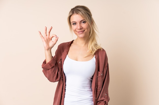 Blonde Frau zeigt ok Zeichen mit den Fingern