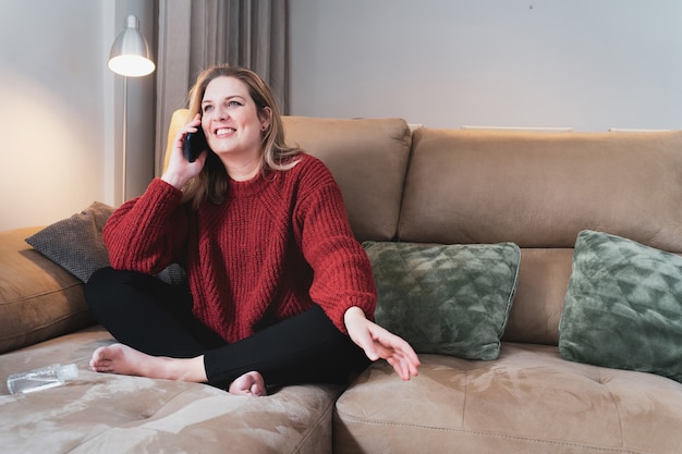 Blonde Frau zu Hause telefoniert