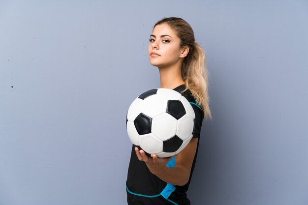 Blonde Fußballspieler-Jugendlichmädchen-Grauwand