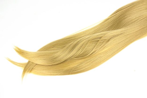 Blonde Haare seidig auf weißem Hintergrund Blondes Haar in Linienform auf weißem Hintergrund