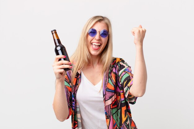 Blonde hübsche Frau, die ein Bier trinkt. Sommerkonzept