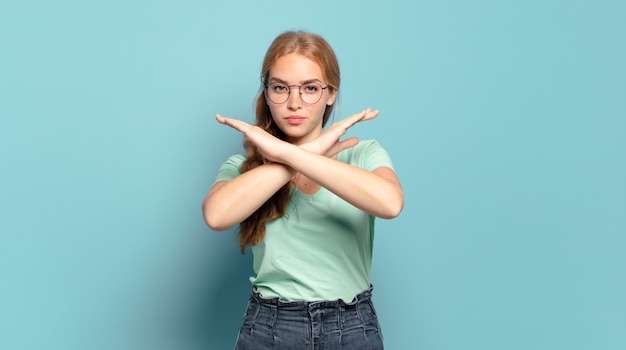 Blonde hübsche Frau, die genervt und krank von Ihrer Einstellung aussieht und genug sagt! Die Hände waren vorne gekreuzt und sagten dir, du sollst aufhören