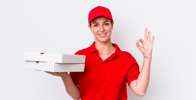 Blonde hübsche frau, die sich glücklich fühlt, die zustimmung mit dem konzept der guten gesten-pizza-lieferung zu zeigen