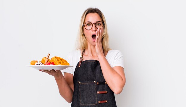 Blonde hübsche Frau, die sich schockiert und verängstigt fühlt, waffelt Konzept