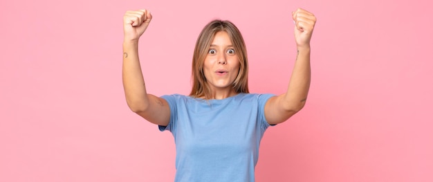 Blonde hübsche Frau, die wie eine Gewinnerin einen unglaublichen Erfolg feiert, aufgeregt aussieht und glücklich sagt, nimm das!