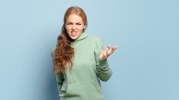 Blonde hübsche Frau, die wütend, genervt und frustriert aussieht und wtf schreit oder was mit dir los ist