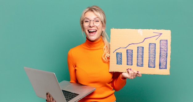 Foto blonde hübsche frau mit ansteigender balkengrafik und einem laptop