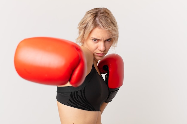 Blonde hübsche Frau mit Boxhandschuhen