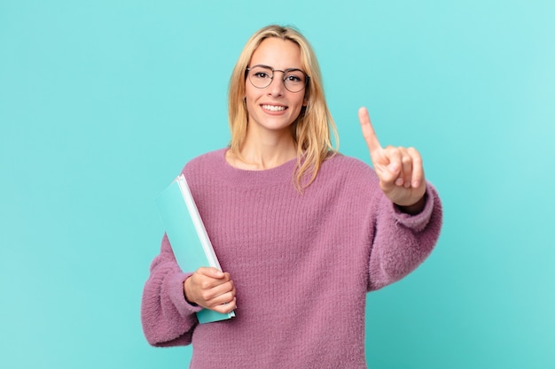 Blonde hübsche frau mit büchern studieren