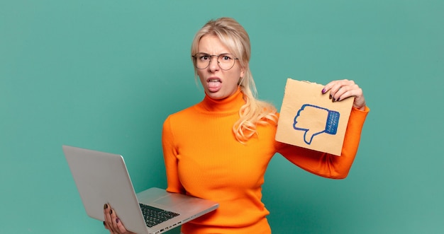 Foto blonde hübsche frau mit einem laptop.