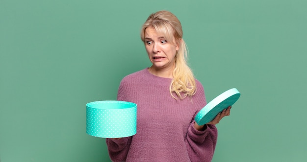 Blonde hübsche Frau mit einer Geschenkbox