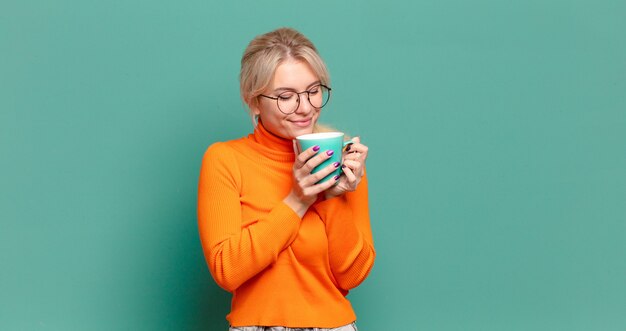 Blonde hübsche Frau mit einer Kaffee- oder Teetasse