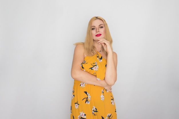 Blonde junge Frau im gelben Blumenfrühlings-Sommerkleid