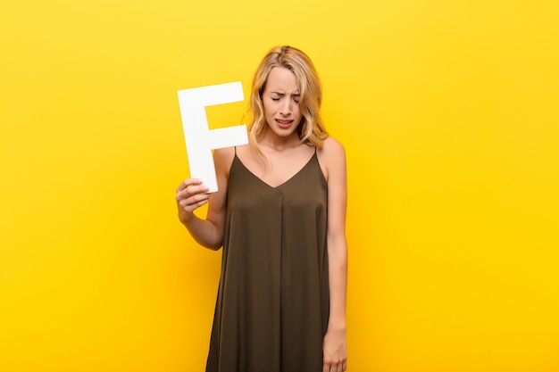 blonde junge Frau in einem Kleid mit dem Buchstaben f