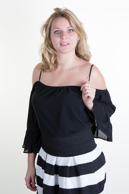 Blonde junge Frau mit einem schwarz-weißen Kleid