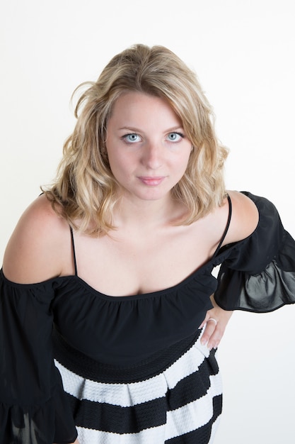 Blonde junge Frau mit einem Schwarzweiss-Kleid
