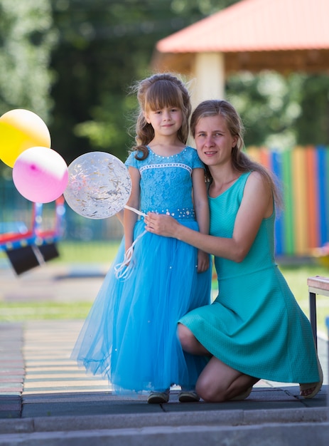 blonde Mutter und kleine Tochter Mädchen im langen blauen Abendkleid