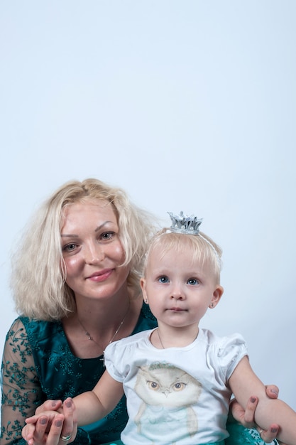 Blonde Mutter und Tochter im Studio auf weißer Oberfläche