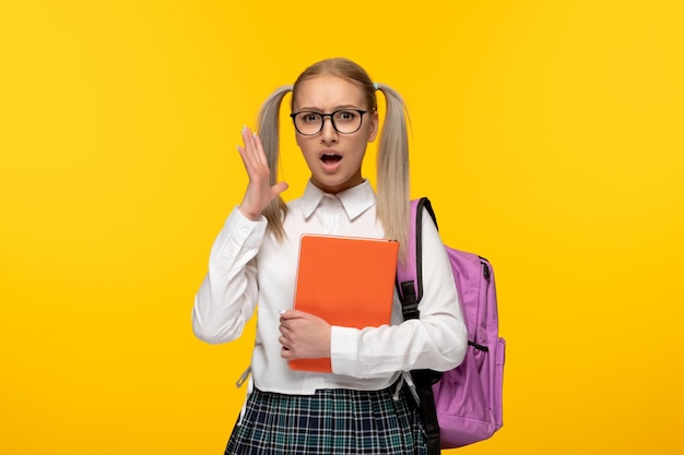 Blonde Studentin des Weltbuchtages hält schockierend Bücher in der Hand