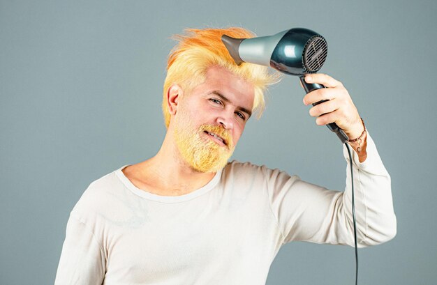 Blonder bärtiger mann mit föhn haarpflege männlich isoliert