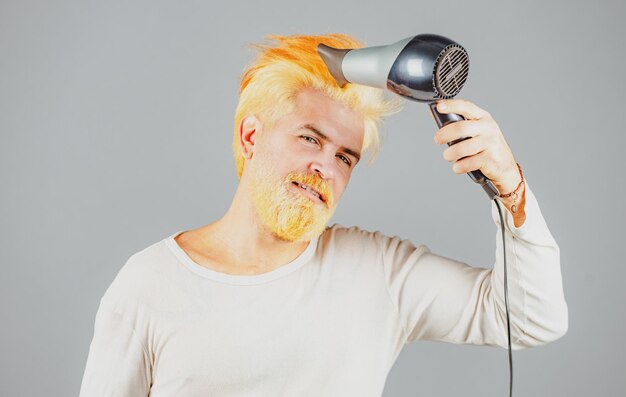 Blonder bärtiger Mann mit Haartrockner Haarpflege männlich isoliert