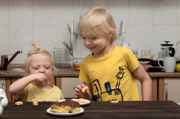 Blonder Bruder und Schwester frühstücken in der Küche. Freundliche Familie.