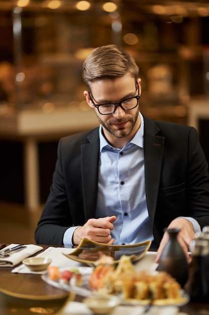 Blonder Herr, der auf den Tisch im Restaurant herabschaut