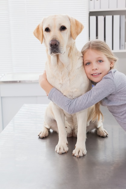 Blonder Inhaber, der ihren netten Hund umarmt