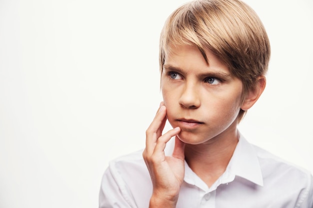 Blonder Junge, der mit seiner Hand denkt