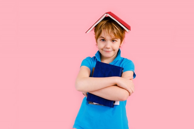 Blonder Junge im T-Shirt, der mit einem Buch herumalbert