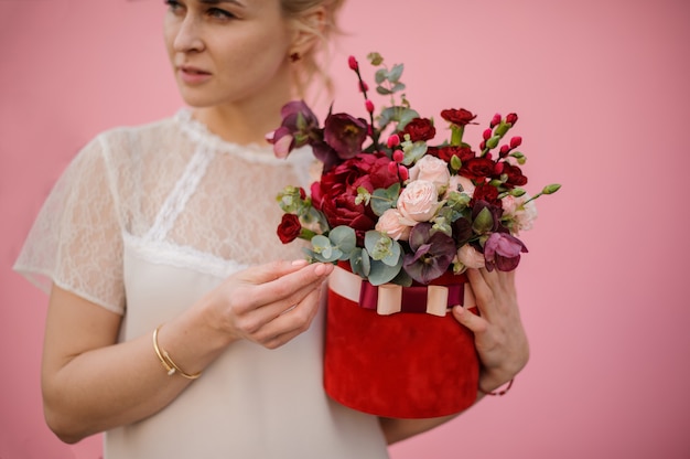 Blonder Mädchengriffblumenstrauß in der Hutschachtel