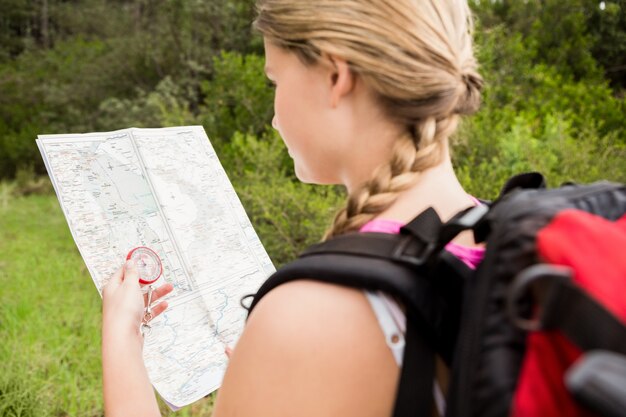 Foto blonder wanderer mit kompass- und lesekarte