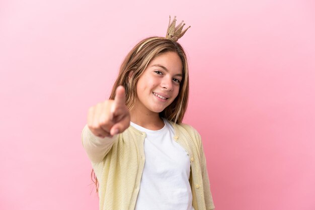 Blondes Fußballspieler-Teenagermädchen über grauer Wand zeigt mit einem selbstbewussten Ausdruck mit dem Finger auf dich