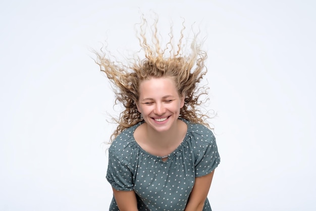 Blondes junges Model im Studio mit vom Wind verwehten Haaren