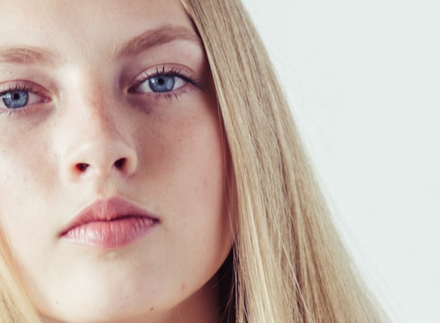 Blondes junges Modell des langen Haares. Schönheitsmädchen mit lockiger perfekter Frisur. Studioaufnahme.