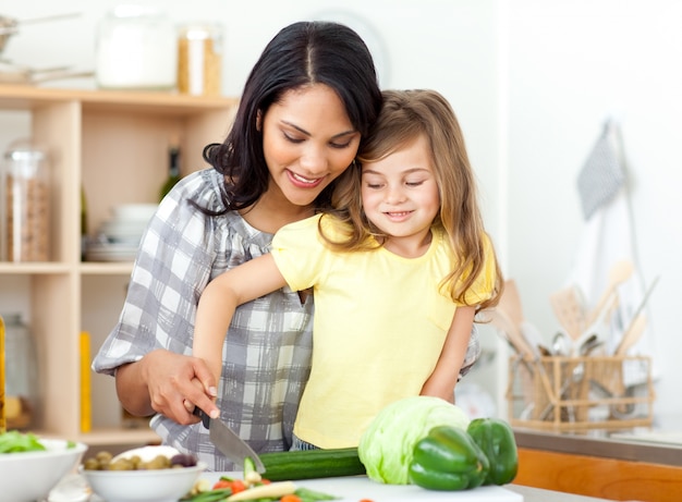 Blondes Kinderausschnittgemüse mit ihrer Mutter