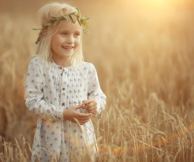 Blondes kleines Mädchen auf dem Feld mit Ährchen