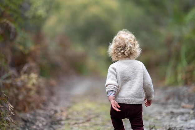 Blondes Kleinkind spaziert in einem Wald auf einer Wanderung im Frühling in einem Nationalpark