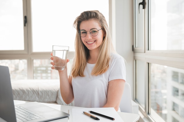 Blondes Mädchen am Trinkwasser der Arbeit