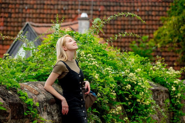 Blondes Mädchen bleiben in der Nähe von alten Stadtfliesenhäusern in Europa