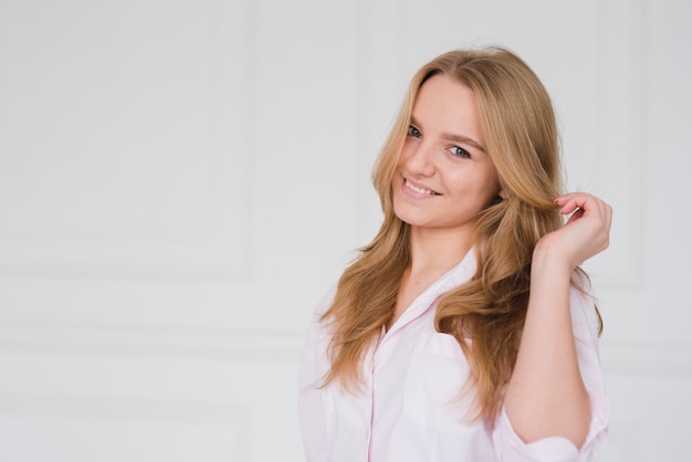 Blondes Mädchen, das ihr Haar berührt