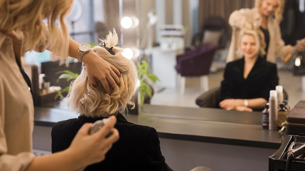 Foto blondes mädchen, das ihr haar erledigt erhält