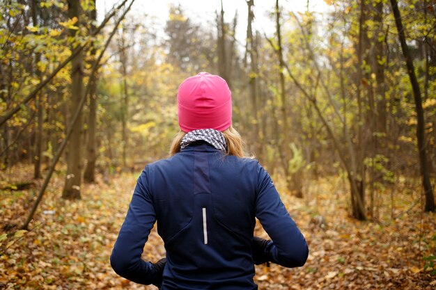 Blondes Mädchen, das morgens im Herbstpark joggt