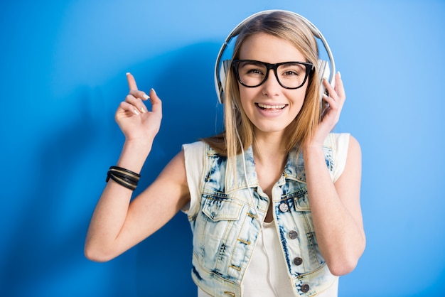 Blondes Mädchen hört Musik mit Kopfhörer.