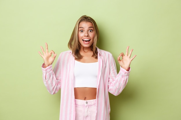 Blondes Mädchen in einem rosa Outfit posiert