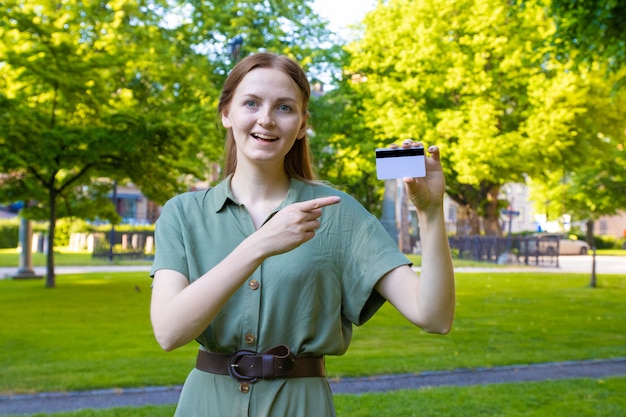 Blondes Mädchen mit Kreditkarte in einem Park